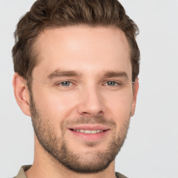 Joyful white young-adult male with short  brown hair and grey eyes