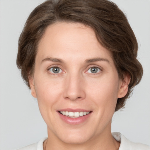 Joyful white adult female with medium  brown hair and grey eyes