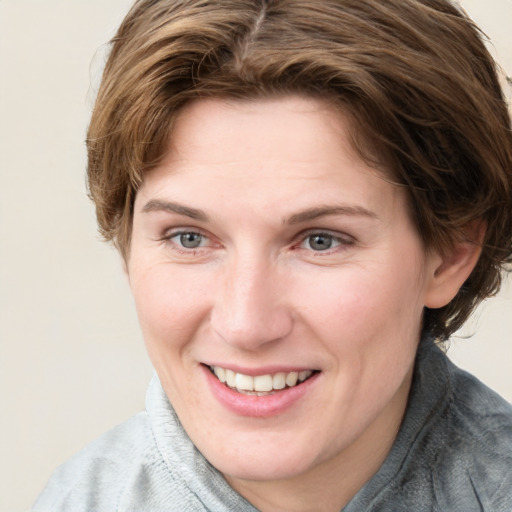 Joyful white young-adult female with medium  brown hair and blue eyes