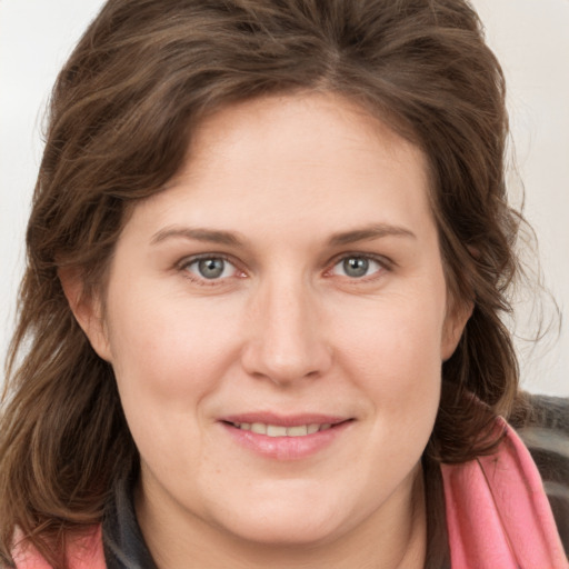 Joyful white young-adult female with long  brown hair and grey eyes