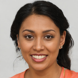 Joyful latino young-adult female with medium  brown hair and brown eyes