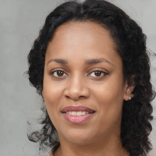 Joyful latino adult female with medium  brown hair and brown eyes