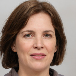 Joyful white adult female with medium  brown hair and grey eyes