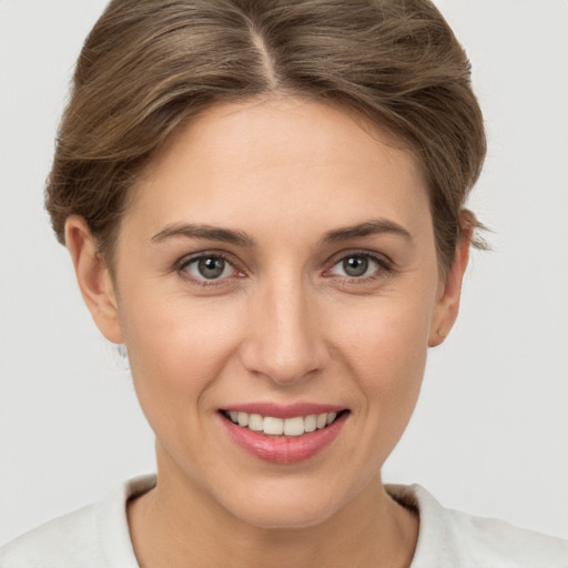 Joyful white young-adult female with short  brown hair and grey eyes