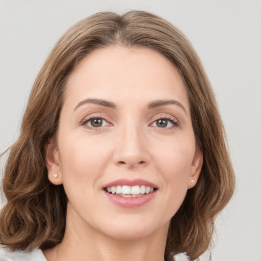 Joyful white young-adult female with medium  brown hair and green eyes