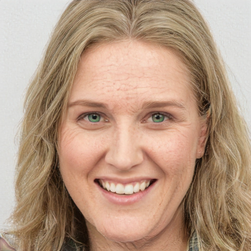 Joyful white adult female with long  brown hair and green eyes