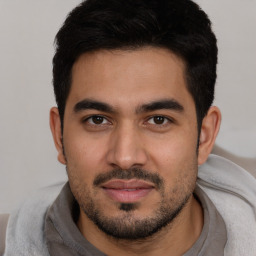 Joyful white young-adult male with short  black hair and brown eyes