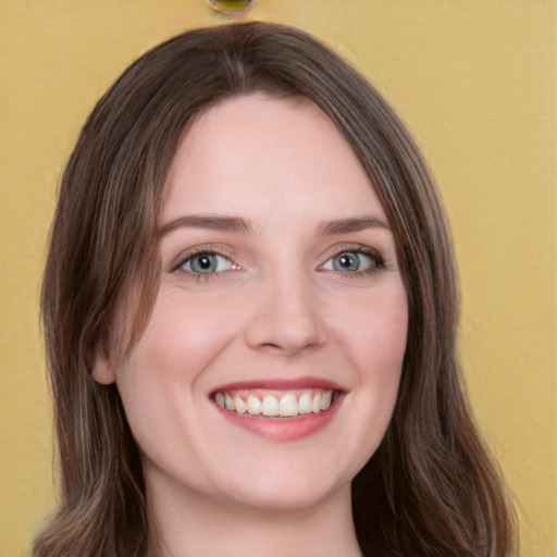 Joyful white young-adult female with long  brown hair and green eyes