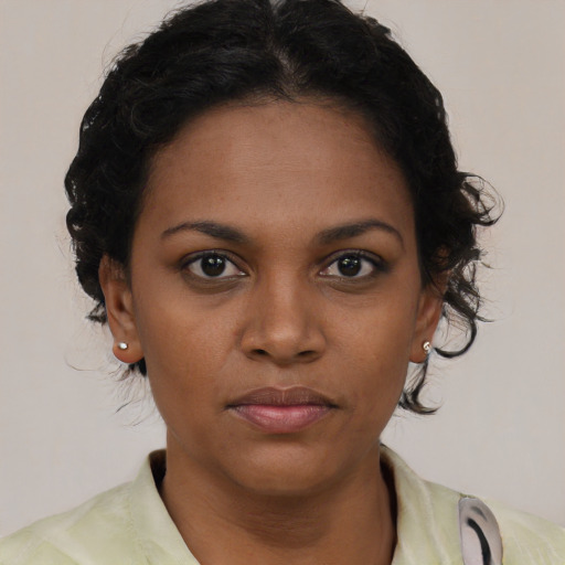 Joyful black young-adult female with short  brown hair and brown eyes
