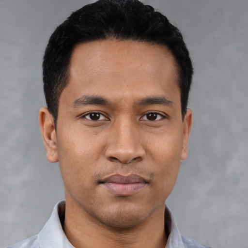 Joyful latino young-adult male with short  black hair and brown eyes