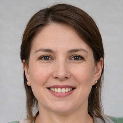 Joyful white young-adult female with medium  brown hair and grey eyes