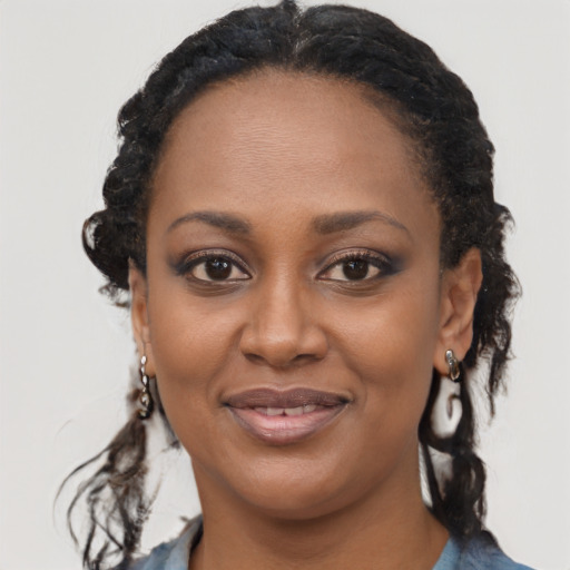 Joyful black young-adult female with long  brown hair and brown eyes