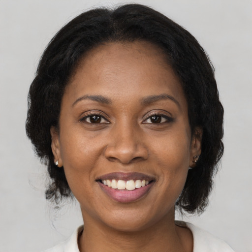 Joyful black adult female with medium  brown hair and brown eyes