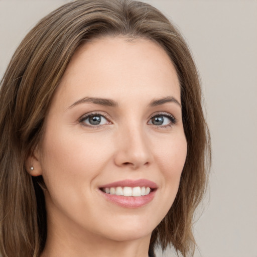 Joyful white young-adult female with long  brown hair and grey eyes