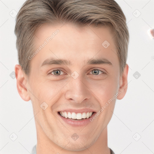 Joyful white young-adult male with short  brown hair and grey eyes