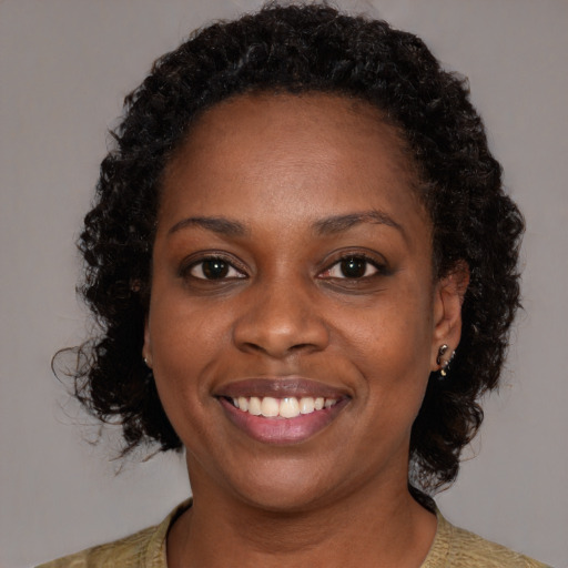 Joyful black young-adult female with medium  brown hair and brown eyes