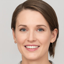 Joyful white young-adult female with medium  brown hair and grey eyes