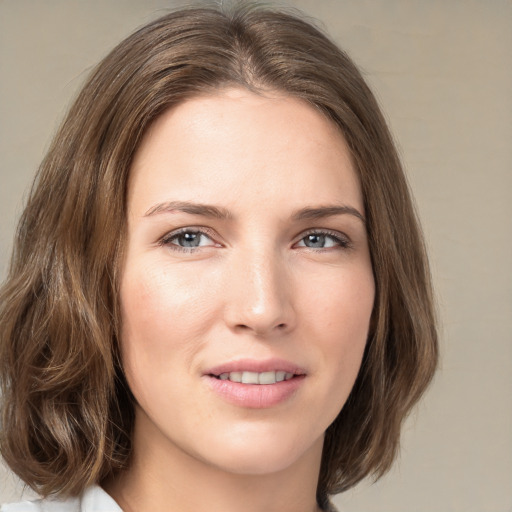 Joyful white young-adult female with medium  brown hair and green eyes