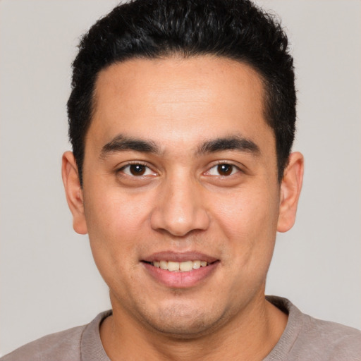 Joyful white young-adult male with short  black hair and brown eyes