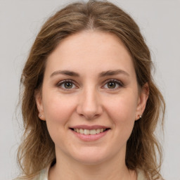 Joyful white young-adult female with medium  brown hair and grey eyes