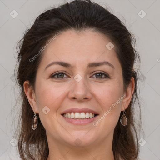 Joyful white adult female with long  brown hair and grey eyes