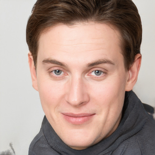 Joyful white young-adult male with short  brown hair and blue eyes