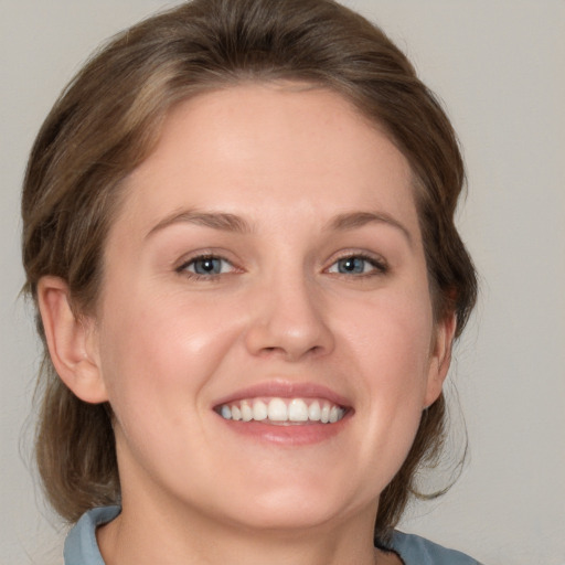 Joyful white young-adult female with medium  brown hair and grey eyes