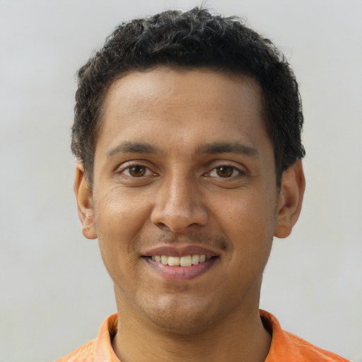 Joyful black young-adult male with short  brown hair and brown eyes