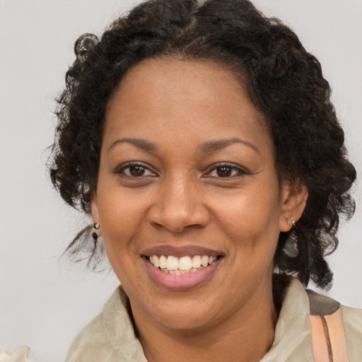 Joyful black adult female with medium  brown hair and brown eyes