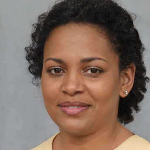 Joyful black young-adult female with medium  brown hair and brown eyes