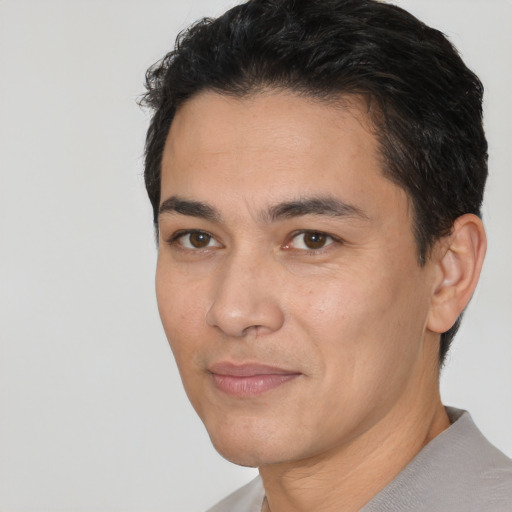 Joyful white young-adult male with short  black hair and brown eyes