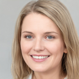 Joyful white young-adult female with long  brown hair and blue eyes