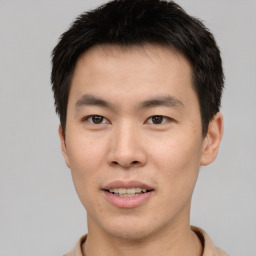 Joyful asian young-adult male with short  brown hair and brown eyes