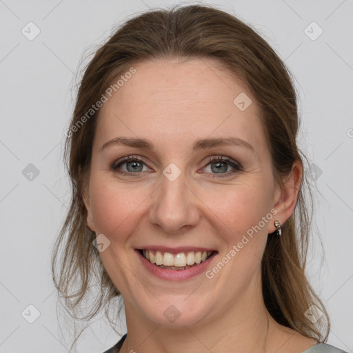 Joyful white adult female with medium  brown hair and grey eyes