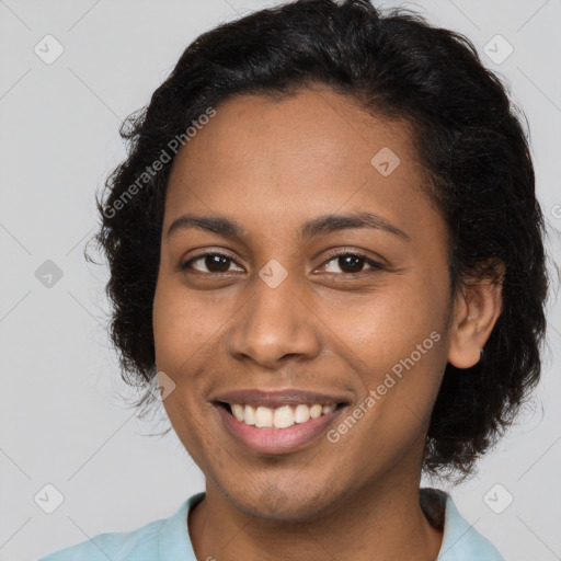 Joyful black young-adult female with long  brown hair and brown eyes