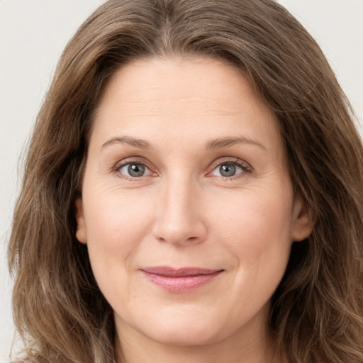 Joyful white young-adult female with long  brown hair and green eyes