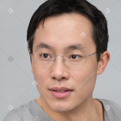 Joyful asian young-adult male with short  brown hair and brown eyes