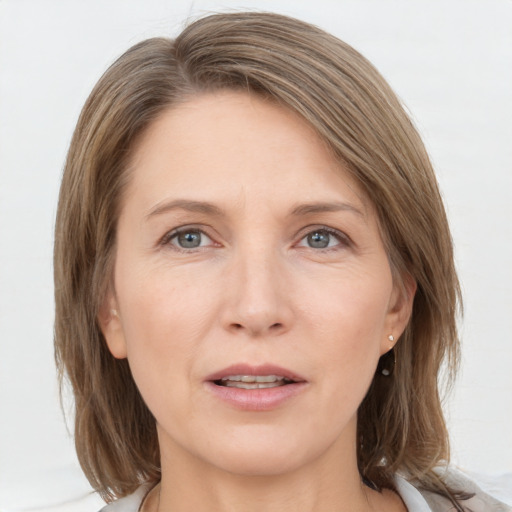 Joyful white adult female with medium  brown hair and grey eyes