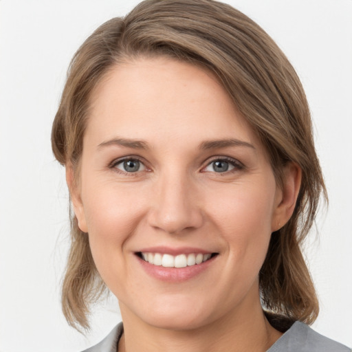 Joyful white young-adult female with medium  brown hair and grey eyes