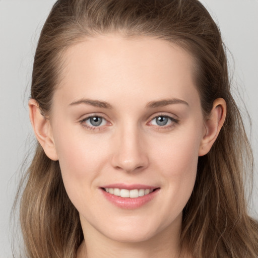 Joyful white young-adult female with long  brown hair and grey eyes