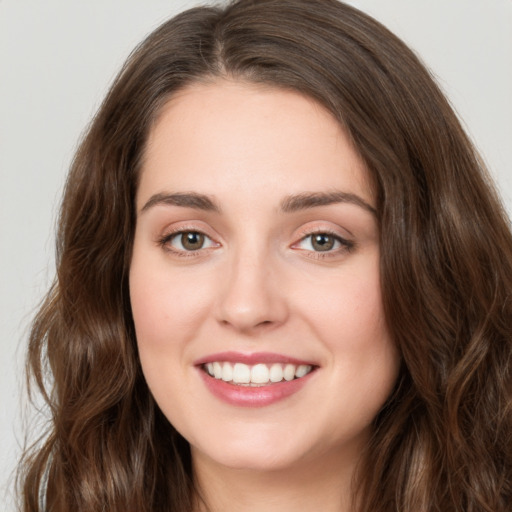 Joyful white young-adult female with long  brown hair and green eyes