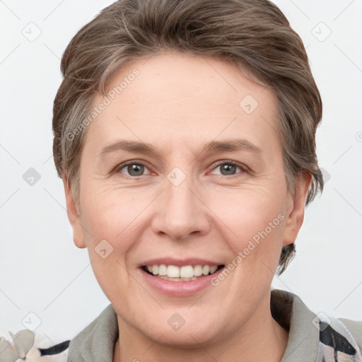 Joyful white adult female with short  brown hair and grey eyes