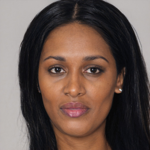 Joyful black young-adult female with long  black hair and brown eyes