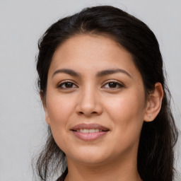 Joyful latino young-adult female with long  brown hair and brown eyes