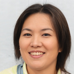 Joyful asian young-adult female with medium  brown hair and brown eyes