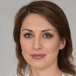 Joyful white young-adult female with medium  brown hair and green eyes