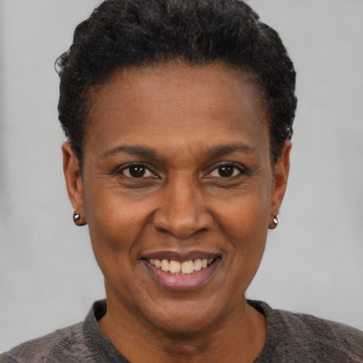 Joyful black adult female with short  black hair and brown eyes