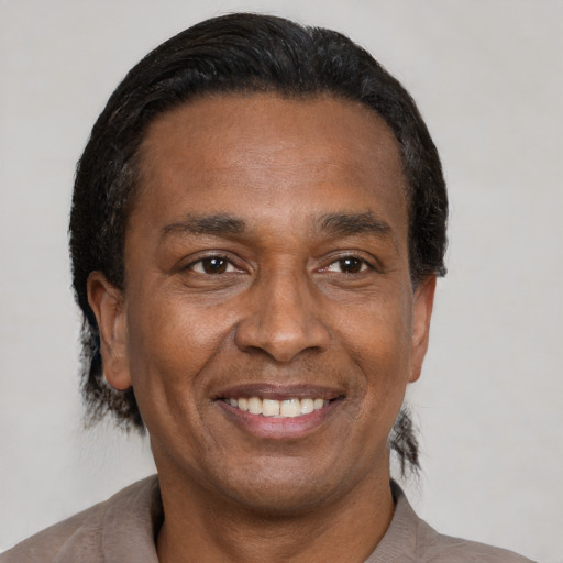 Joyful black adult male with short  black hair and brown eyes