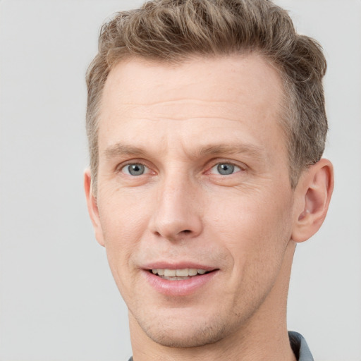 Joyful white adult male with short  brown hair and grey eyes