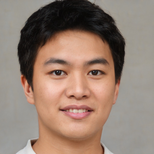 Joyful asian young-adult male with short  brown hair and brown eyes